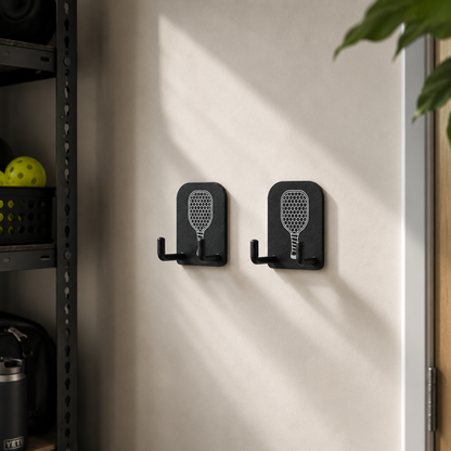 Lot de deux crochets muraux noirs de rangement pour équipement de pickleball avec gravure blanche de raquette.