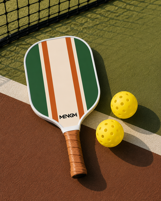 Raquette de pickleball vintage verte avec bandes orange et crème et deux balles de sport perforées.