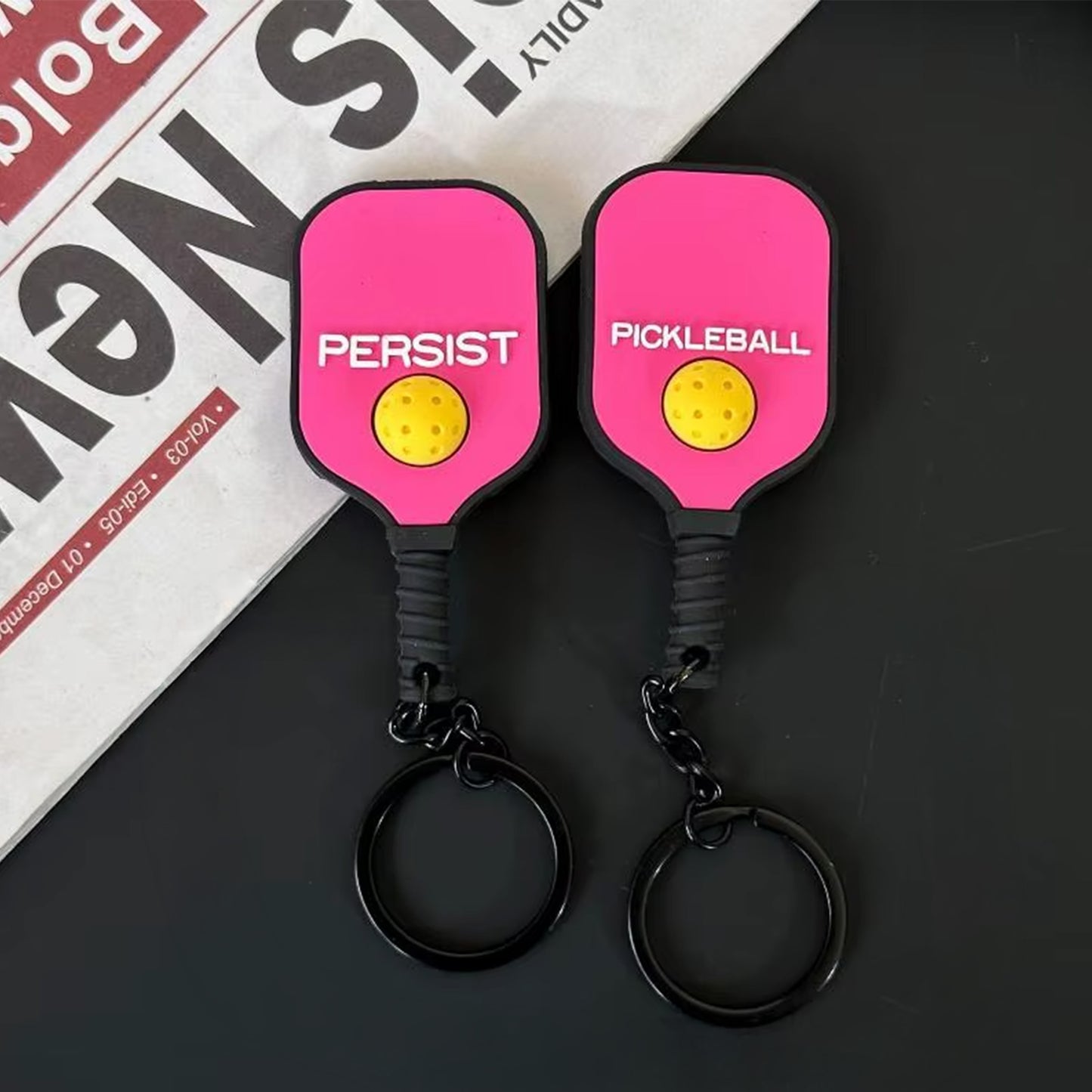 Mini raquette porte-clés rose fuchsia flashy, vue du recto et du verso.