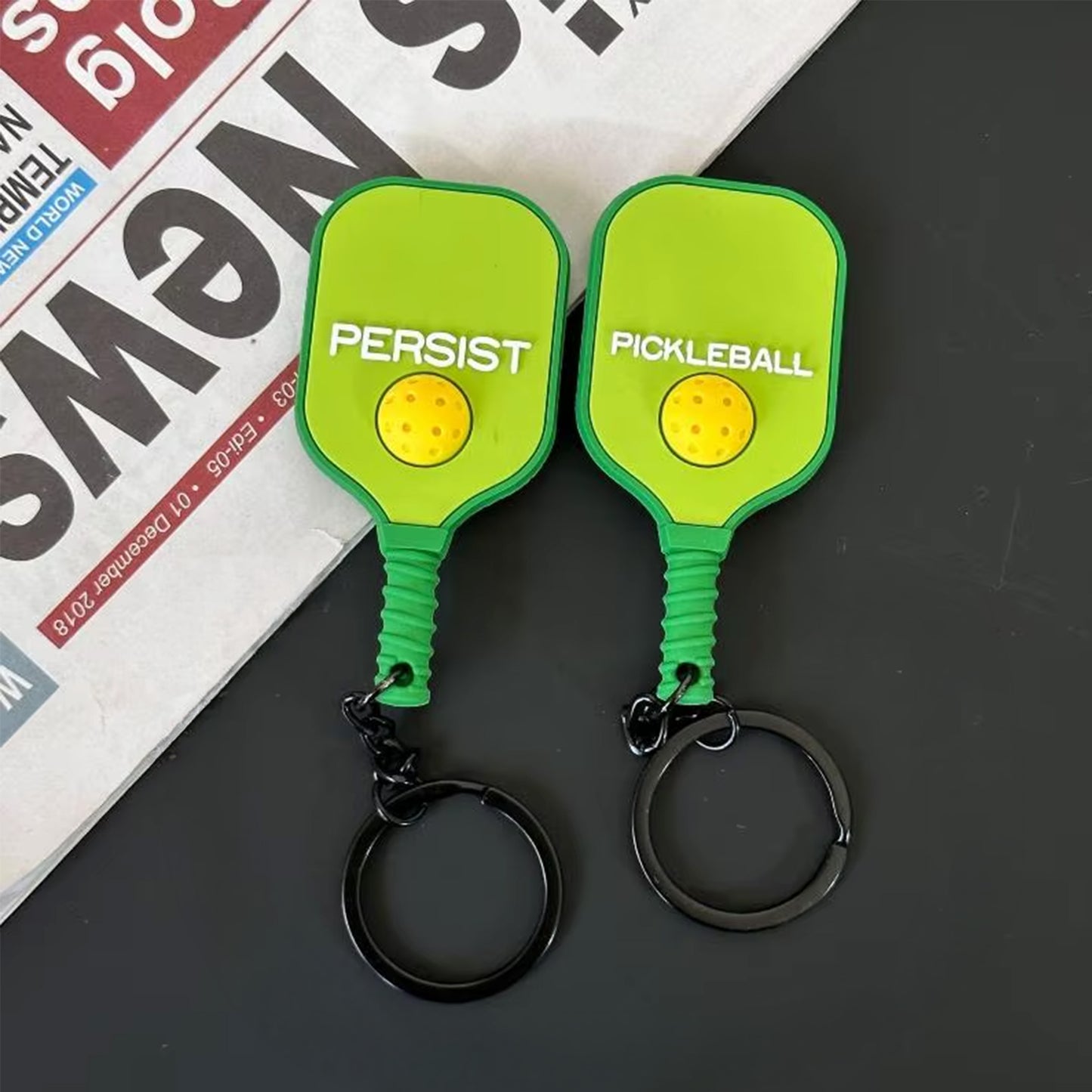 Porte-clés de pickleball vert citron fluorescent, détails des deux faces.