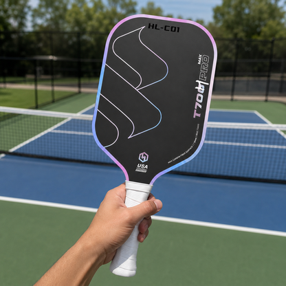 Main tenant la raquette de pickleball premium T700 Pro Max modèle HL-CD1 au-dessus d'un court bleu et vert.