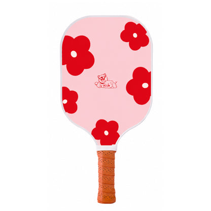 Face recto de la raquette de pickleball en carbone Bloom Pink, couleur rose pastel avec grosses fleurs rouges et illustration de petits animaux au centre.
